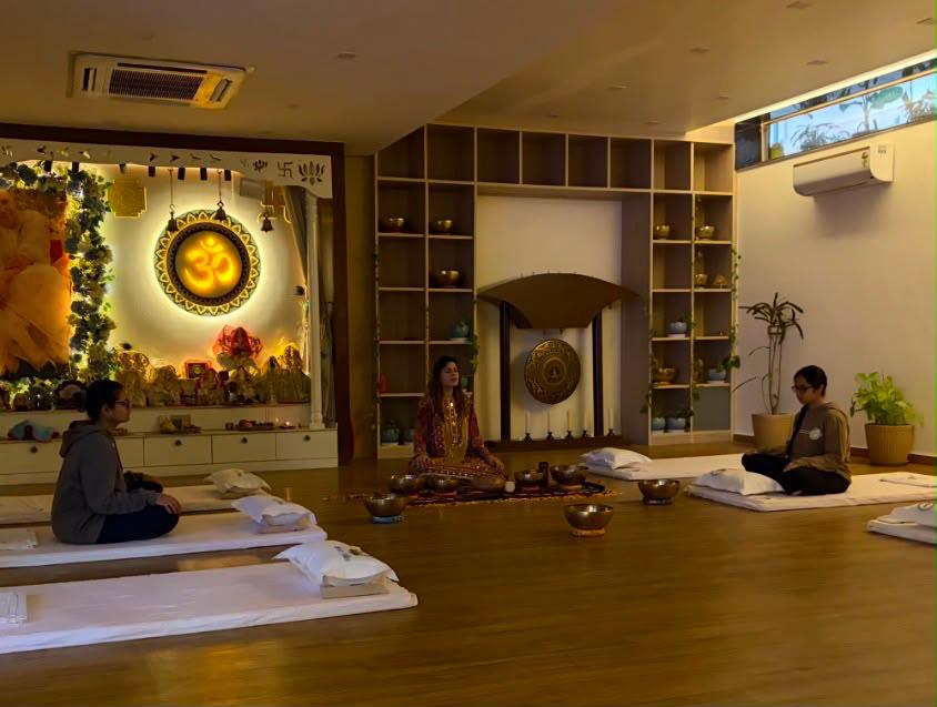 Shanaya Ghai leading an indoor sound healing session with singing bowls